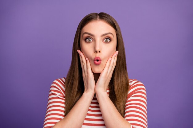 Foto de close da senhora louca fofa engraçada bom humor longo penteado perfeito boca aberta braços de notícias loucas nas bochechas usar camisa listrada casual isolada parede de cor roxa pastel