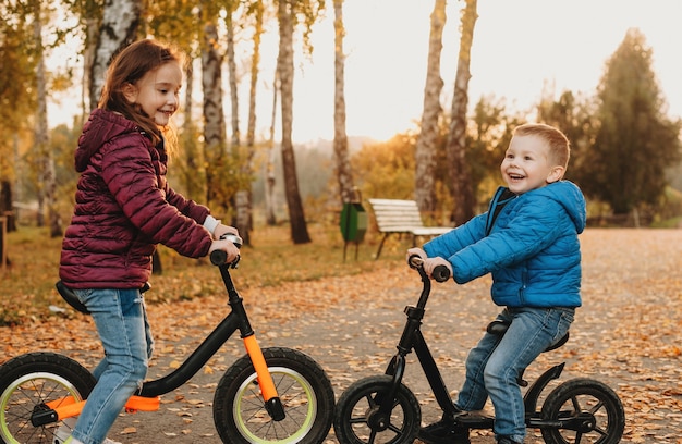 Foto de close de dois irmãos caucasianos que pararam cara a cara em suas bicicletas