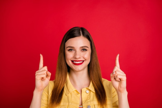 Foto de close de senhora atraente de bom humor dedos diretos para cima espaço vazio novidade compra produto de preço baixo desgaste casual amarelo jaqueta blazer jeans isolado fundo de cor vermelha vívida