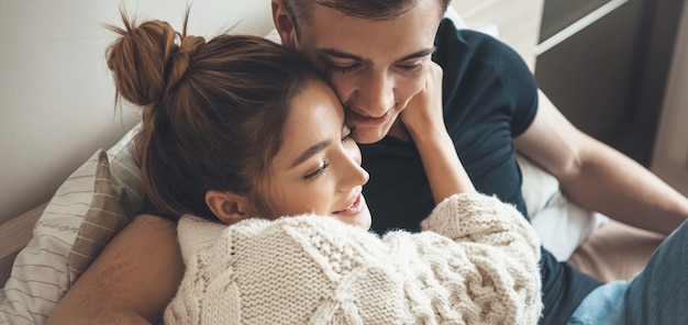 Foto de close de um casal caucasiano se abraçando e passando um tempo juntos em um fim de semana
