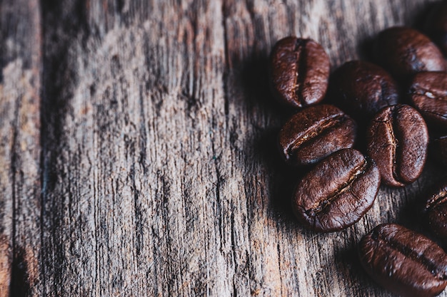 Foto de close-up de grãos de café na madeira.