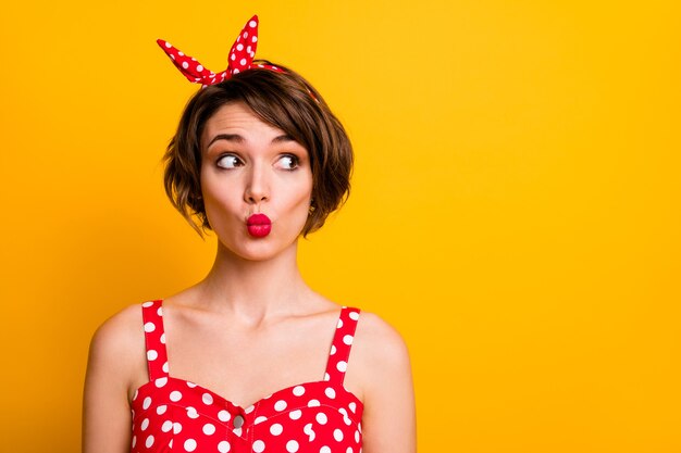 Foto de close-up de linda doce linda garota olhar cópia espaço sentir interessado enviar beijo no ar usar roupa de bolinhas isolada sobre parede de cor brilhante