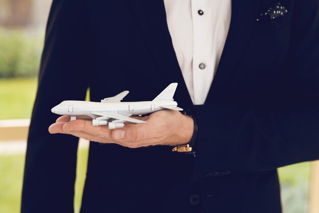 Foto de close-up de um homem em um terno preto segurar aeronaves.