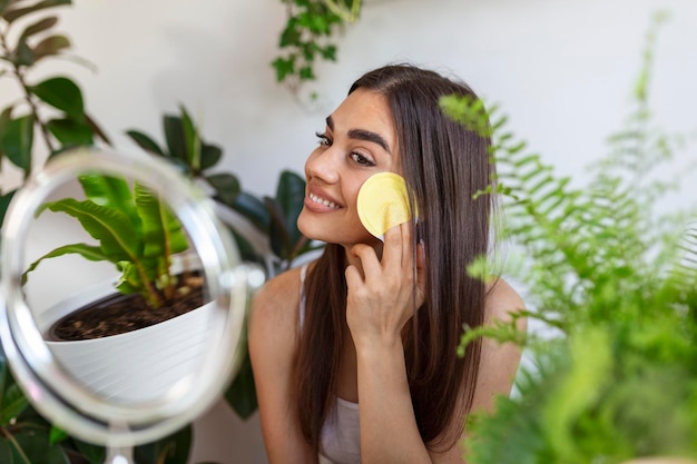 Foto foto de close up na cabeça de uma bela mulher agradável aplicando massagem facial após o banho.