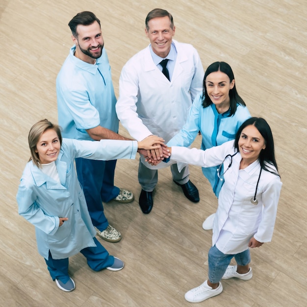 Foto de corpo inteiro da equipe médica feliz e bem-sucedida durante uma conversa no hospital