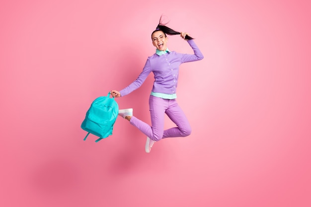 Foto de corpo inteiro da garota pulando, segurando, sacola, cauda, boca aberta, usando óculos, calças pullover roxo, tênis, cor rosa, isolado, fundo