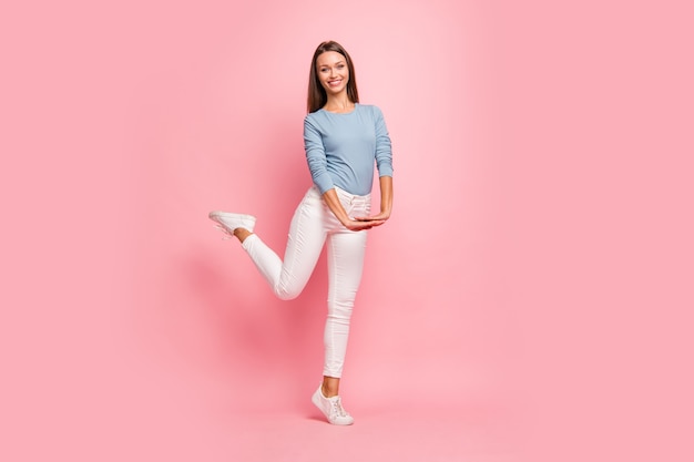 Foto de corpo inteiro de jovem bailarina bonita alegre positiva com as mãos postas perto do espaço vazio isolado fundo de cor pastel