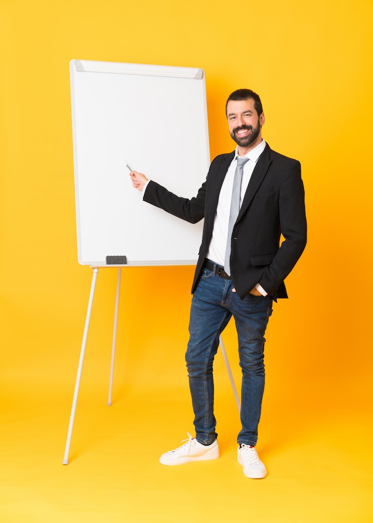 Foto foto de corpo inteiro do empresário dando uma apresentação no quadro branco sobre amarelo isolado
