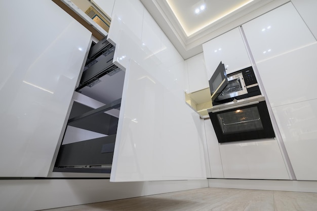 Foto de cozinha moderna branca com gavetas de alto ângulo de visão puxadas para fora