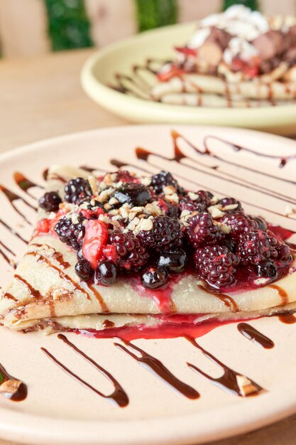 Foto de delicioso crepe com frutas vermelhas amoras mirtilos mirtilos morangos e decoração de chocolate