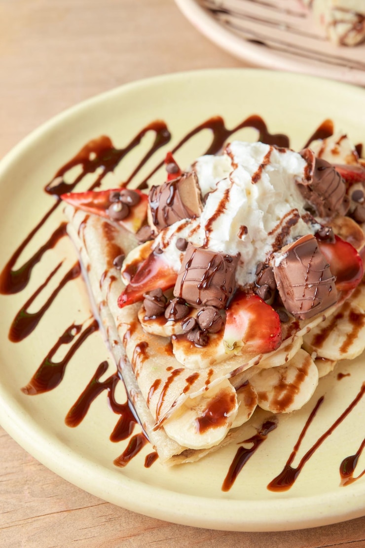Foto foto de delicioso crepe com morangos de banana com chocolate e chantilly