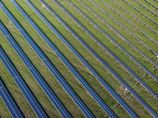 Foto de drone de um grande número de painéis solares azuis próximos um do outro. Cuidando do planeta e do meio ambiente.