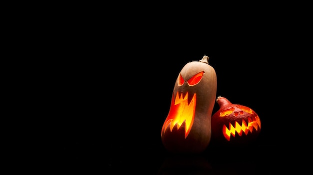 Foto de duas abóboras de halloween com bocas ardentes em fundo preto vazio em estúdio