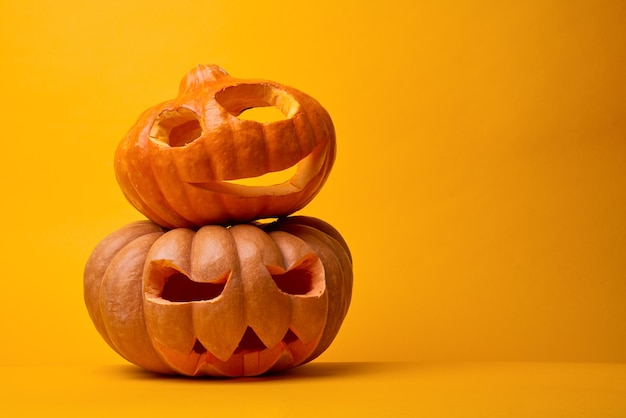 Foto de duas abóboras de halloween em fundo laranja vazio