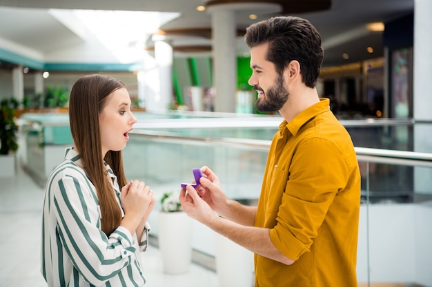 Foto de duas pessoas senhora atraente cara bonito casal visita shopping center namorado faz proposição casar comigo emoção inesperada usar camisa jeans casual dentro de casa