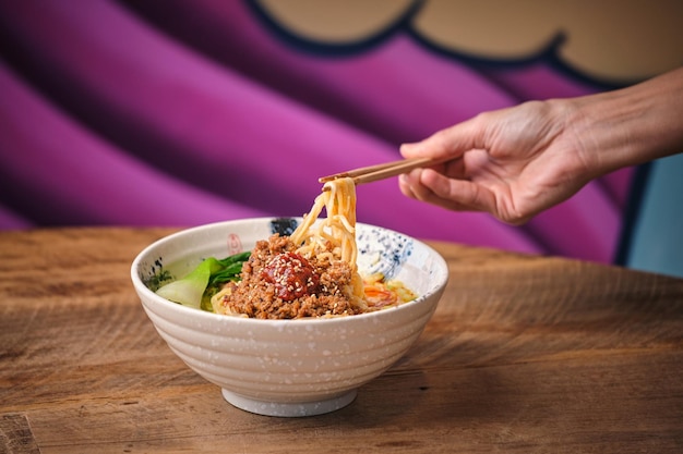 Foto de estoque de pessoa não reconhecida desfrutando de sopa de macarrão em um restaurante japonês.