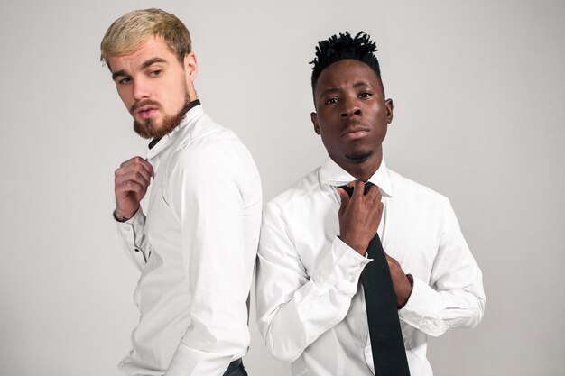 Foto de estúdio de conceito de amizade internacional de dois jovens elegantes em fundo branco