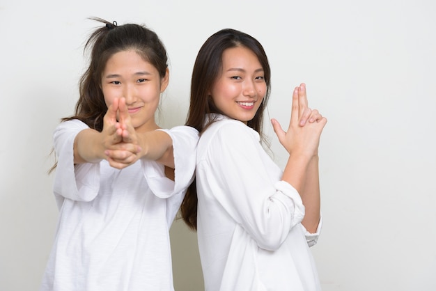 Foto de estúdio de duas jovens coreanas lindas amigas juntas contra um fundo branco