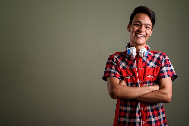 Foto de estúdio de jovem adolescente vestindo uma camisa xadrez vermelha