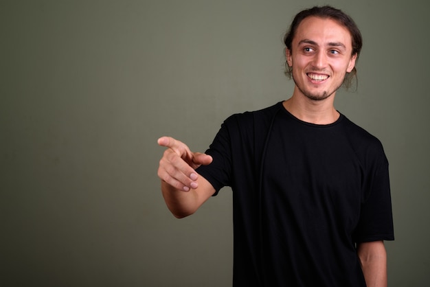 Foto foto de estúdio de jovem bonito vestindo uma camisa preta contra um fundo colorido