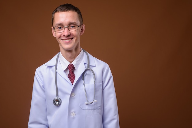 Foto de estúdio de jovem médico em marrom