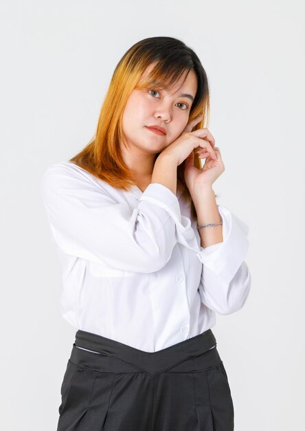 Foto de estúdio de retrato do modelo de empresário de designer feminino confiante jovem asiático em moda casual usa olhar para a câmera segurando a mão toque rosto cruzado em fundo branco.