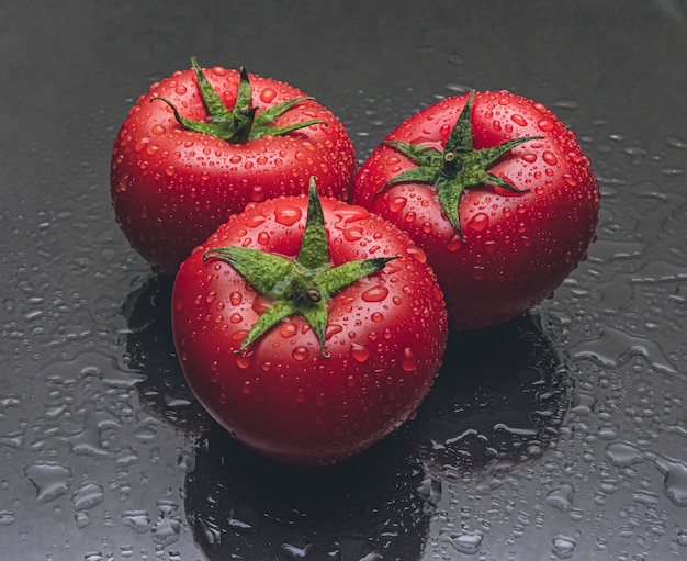 Foto foto de estúdio de três tomates com gotas de água