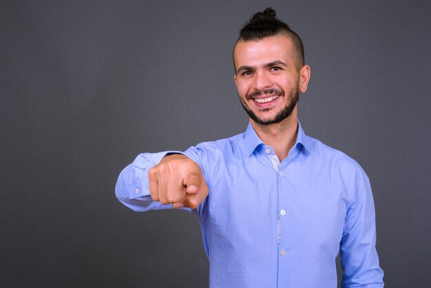 Foto de estúdio de um empresário turco bonito contra um fundo cinza