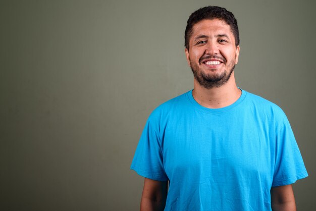 Foto foto de estúdio de um homem barbudo vestindo uma camisa azul contra cores