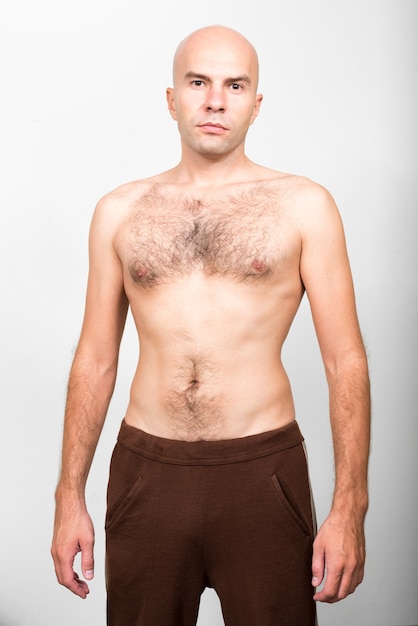 Foto foto de estúdio de um homem careca sem camisa contra um fundo branco