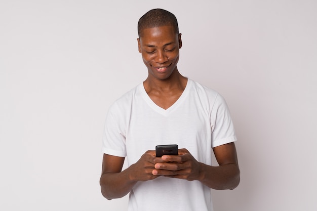 Foto de estúdio de um jovem africano careca contra um fundo branco