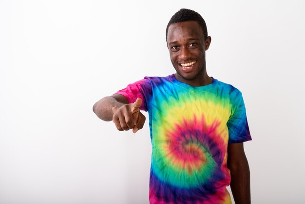 Foto de estúdio de um jovem africano negro feliz apontando o dedo para