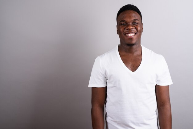 Foto de estúdio de um jovem africano vestindo uma camisa branca contra um fundo branco