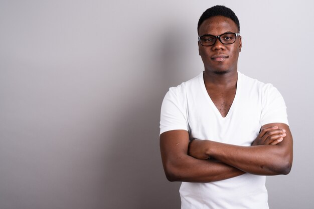 Foto de estúdio de um jovem africano vestindo uma camisa branca e óculos contra um fundo branco