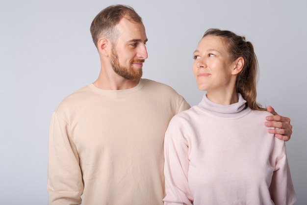 Foto de estúdio de um jovem barbudo e uma jovem mulher bonita juntos contra o branco