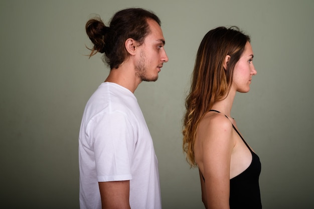 Foto de estúdio de um jovem bonito e uma jovem mulher bonita juntos contra um fundo colorido