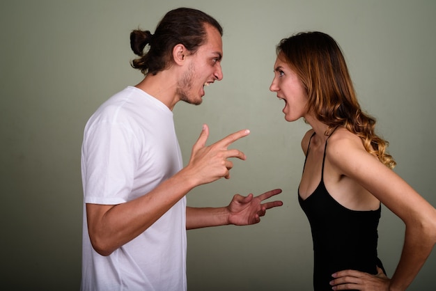 Foto foto de estúdio de um jovem bonito e uma jovem mulher bonita juntos contra um fundo colorido