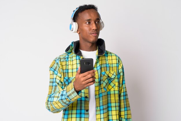 Foto de estúdio de um jovem bonito moderno africano com cabelo afro contra branco