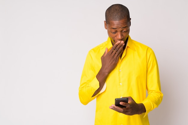 Foto de estúdio de um jovem empresário africano careca contra um fundo branco