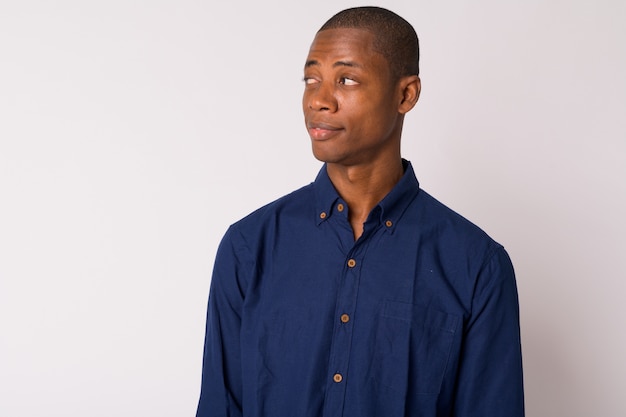 Foto de estúdio de um jovem empresário africano careca contra um fundo branco