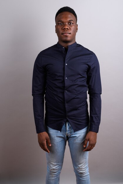 Foto de estúdio de um jovem empresário africano vestindo uma camisa azul contra um fundo branco