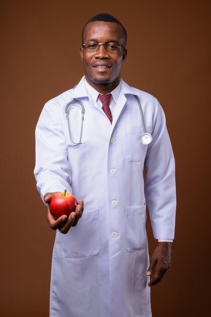 Foto de estúdio de um jovem médico africano contra um fundo marrom