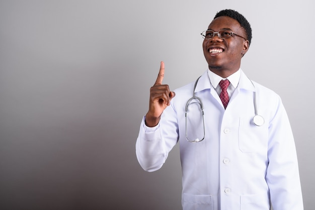 Foto de estúdio de um jovem médico africano usando óculos contra um fundo branco