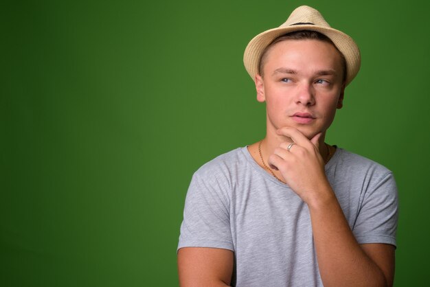 Foto de estúdio de um jovem turista bonito contra um fundo verde