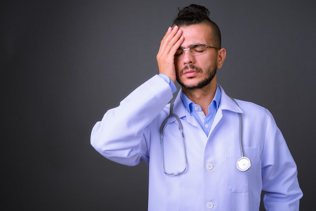 Foto de estúdio de um médico turco bonito contra um fundo cinza