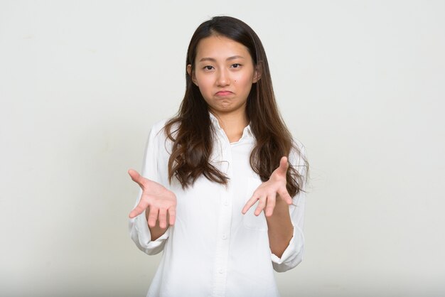 Foto de estúdio de uma bela jovem empresária coreana contra um fundo branco