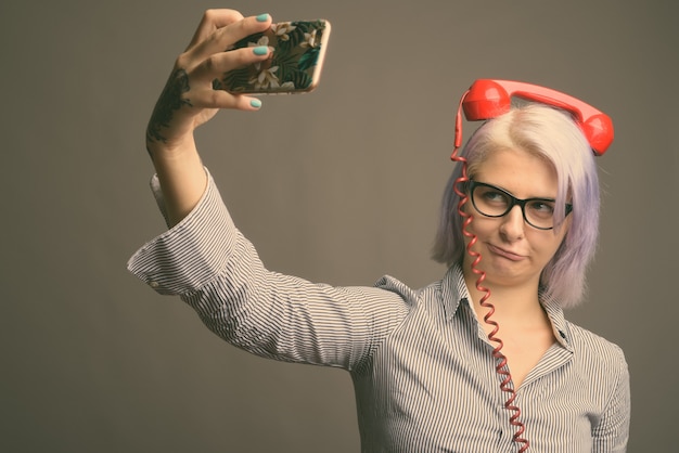 Foto de estúdio de uma jovem mulher de negócios bonita com cabelo curto colorido na cor cinza