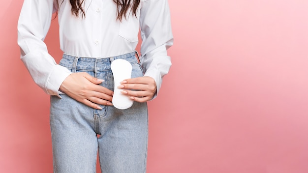 Foto foto de estúdio de uma jovem sentindo a dor da menstruação com um pantyliner nas mãos espaço para o texto