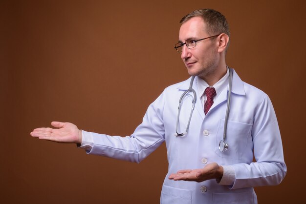 Foto de estúdio do homem médico em marrom