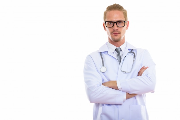 Foto de estúdio do médico jovem bonito com os braços cruzados